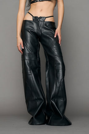 Low-rise flared pants in black faux leather with bold side cut-outs and thong strap detailing. Featuring moto-style paneling, front zip closure, and a sculpted fit. A statement piece for rave, nightlife, and runway-inspired looks.