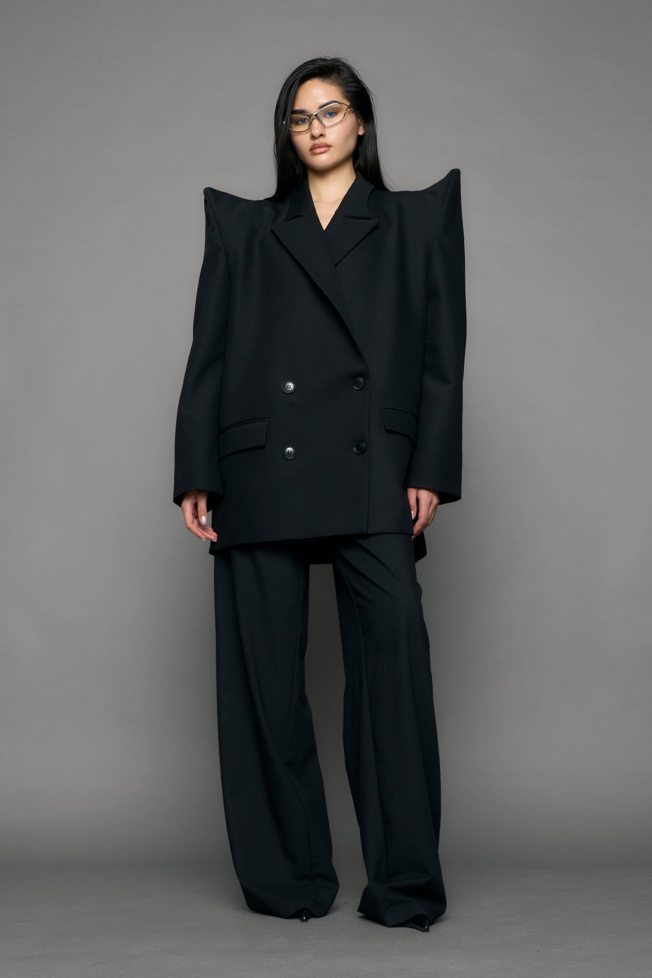 model wearing black blazer with sharp shoulder design