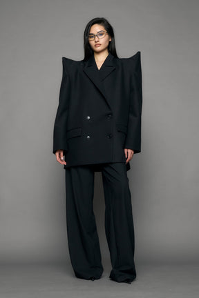 model wearing black blazer with sharp shoulder design