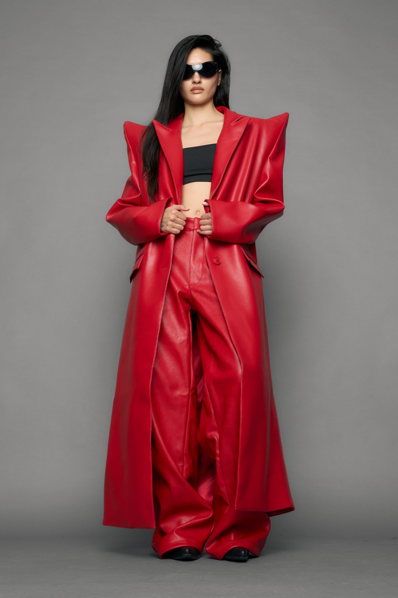 model wearing red pu leather coat with sharp shoulder design