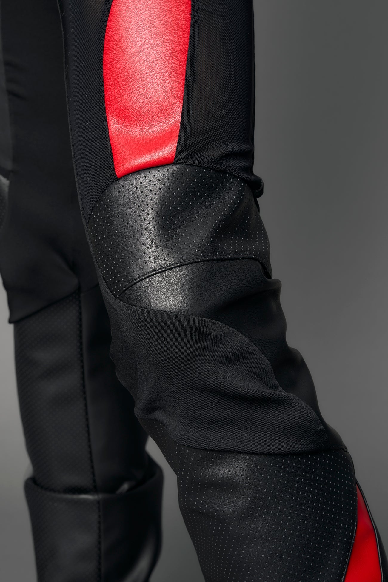 model wearing black red moto mesh pants