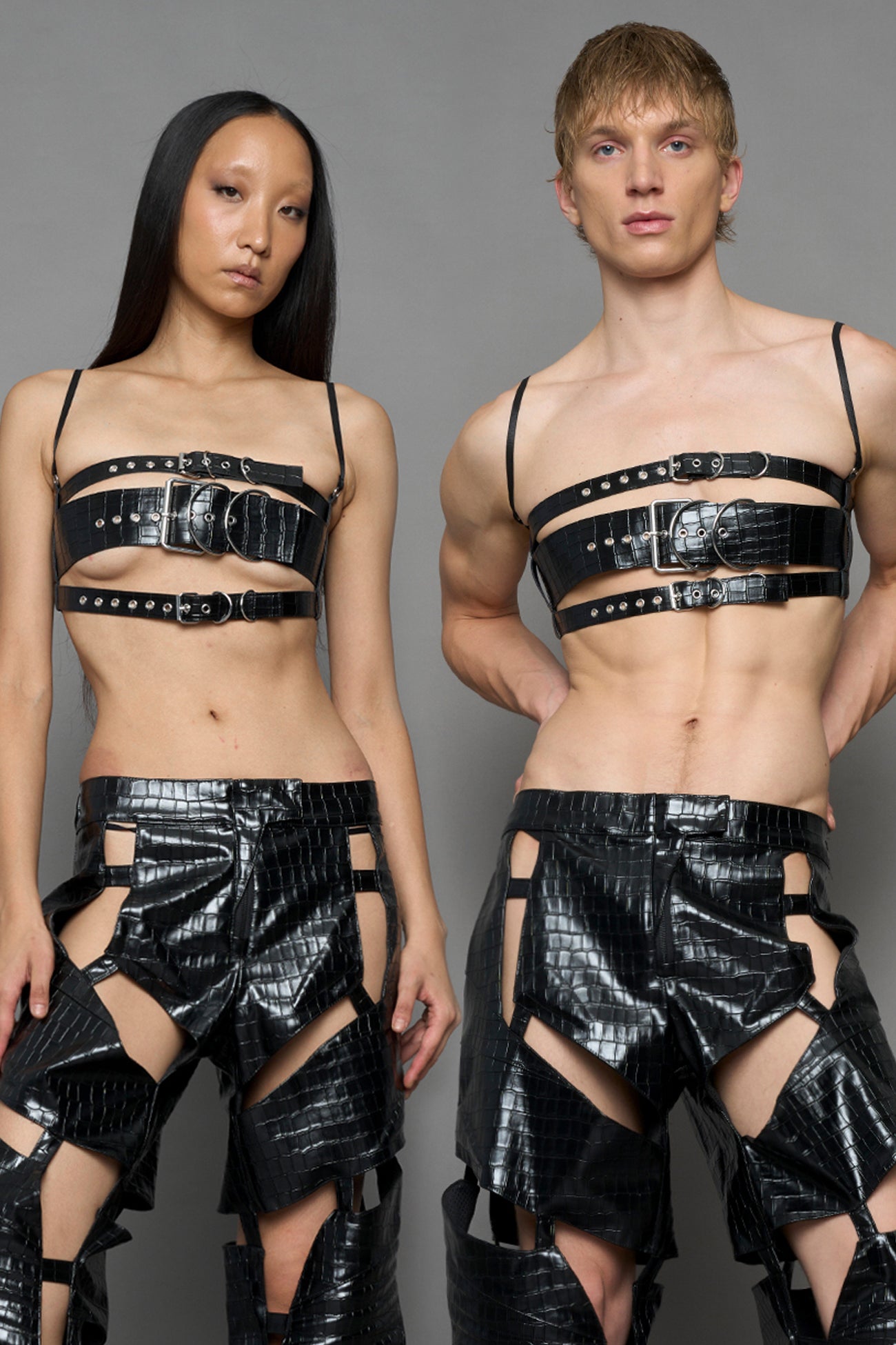 two models wearing black vegan leather croc inspired belt top with buckle details and matching pants