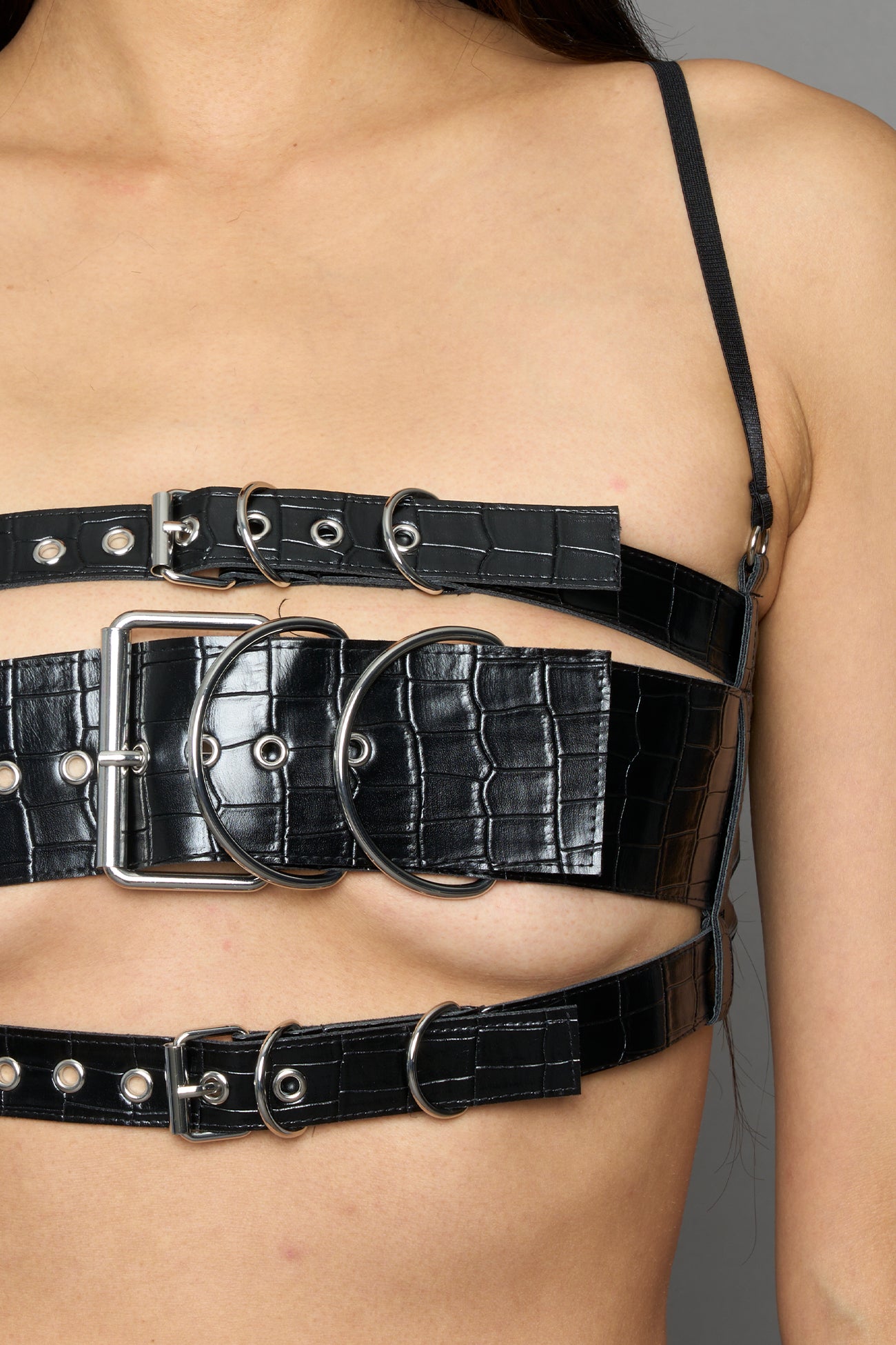 model wearing black vegan leather croc inspired belt top with buckle details