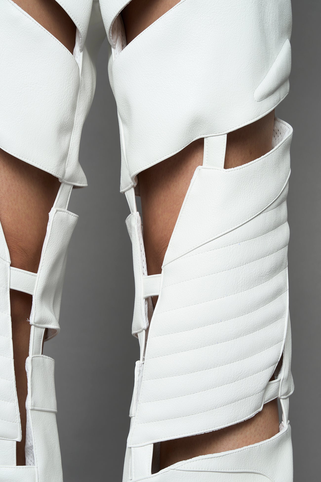 model wearing white vegan leather pants with cut out details