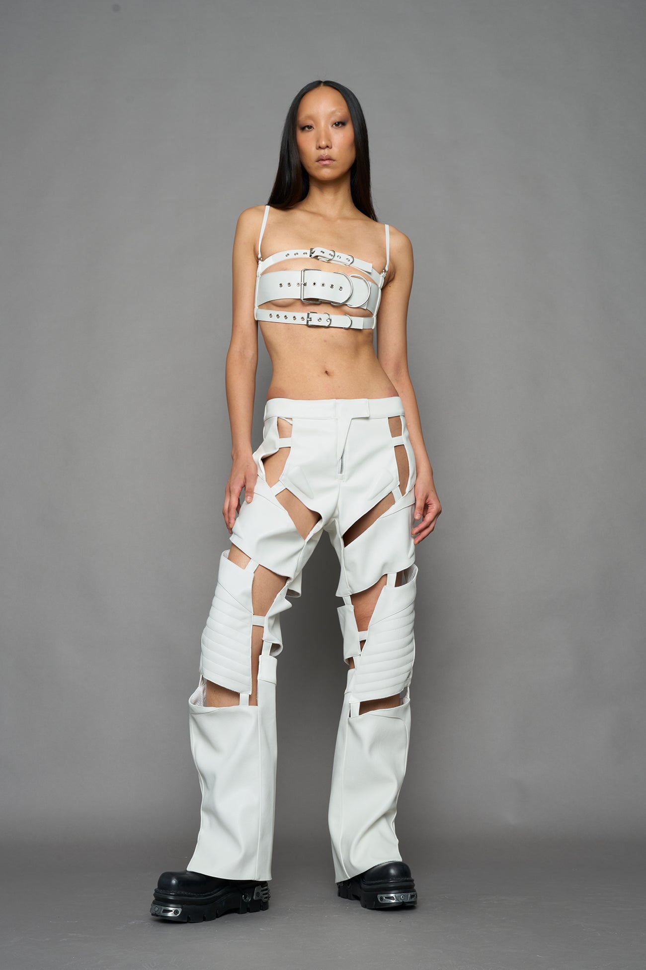 model wearing white vegan leather pants with cut out details