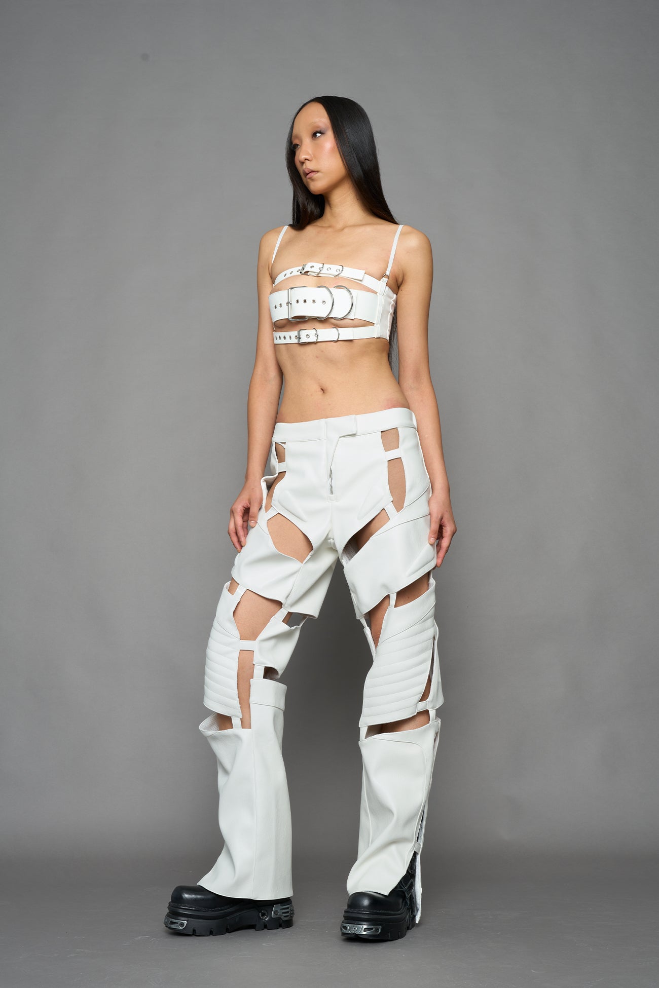 model wearing white vegan leather pants with cut out details