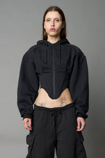 model wears black oversize hoodie with integrated corset
