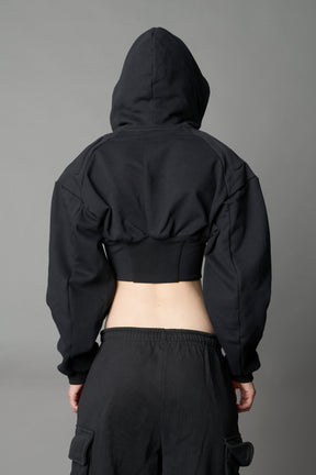 model wears black oversize hoodie with integrated corset