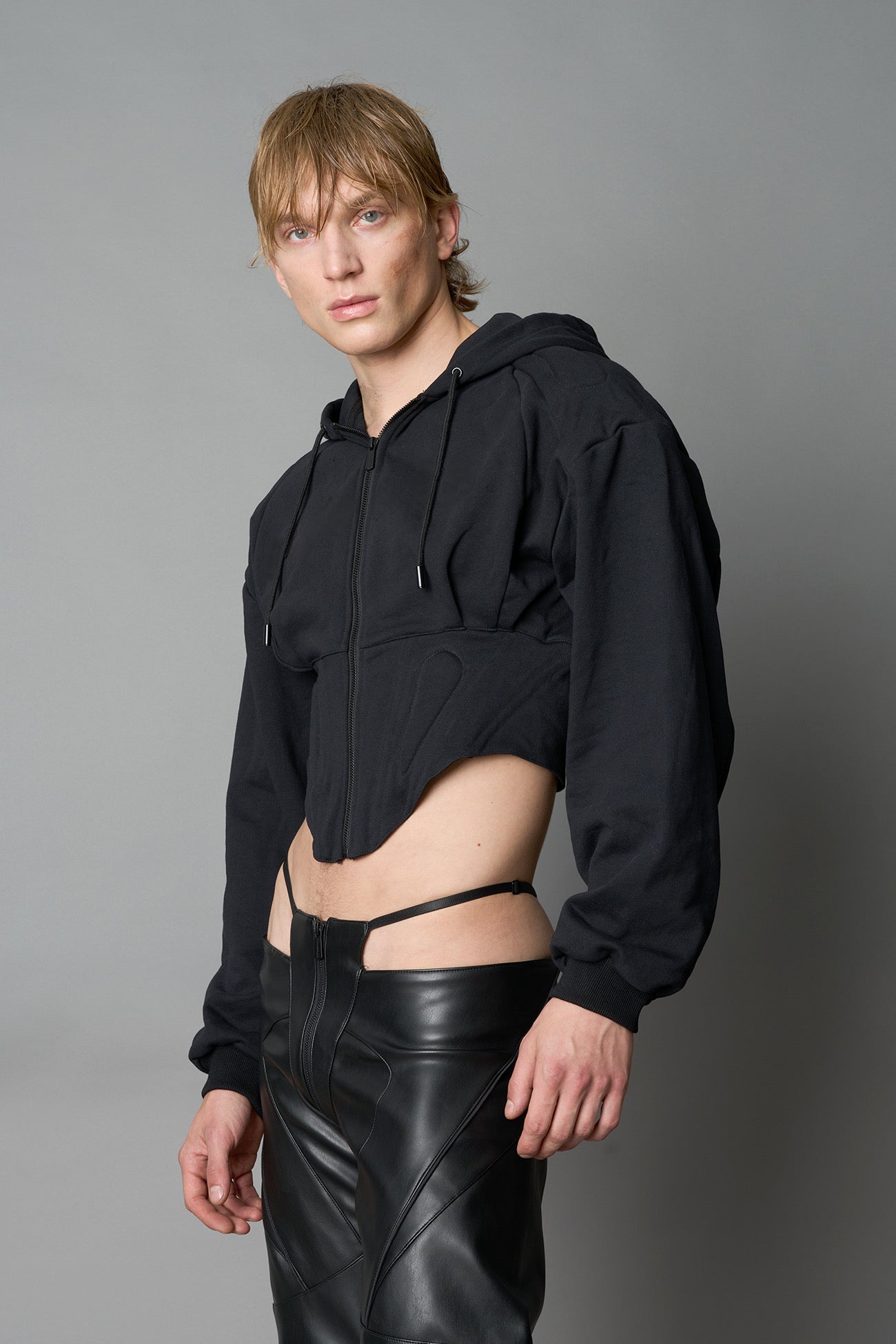 model wears black oversize hoodie with integrated corset