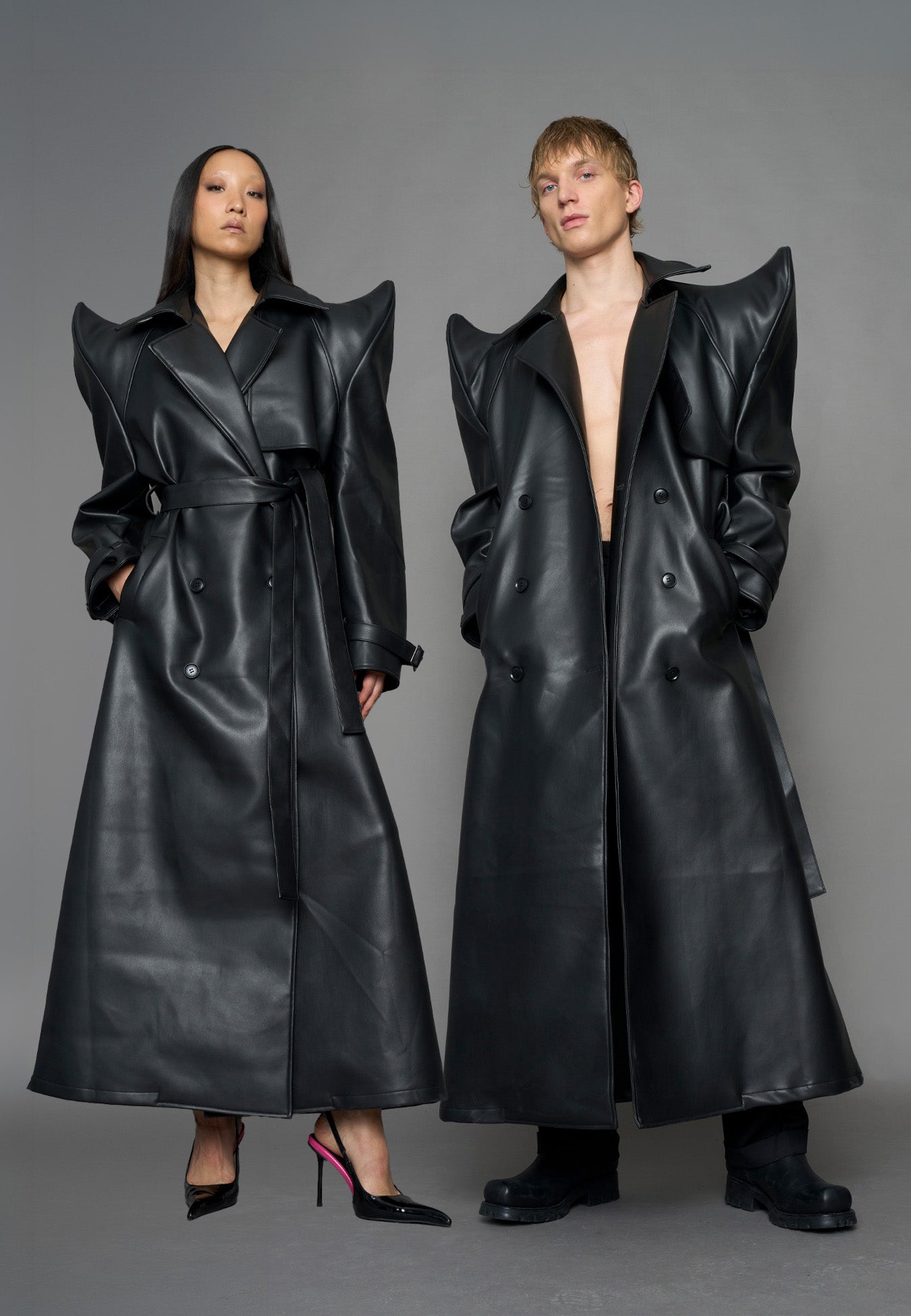 model wearing black vegan leather trench coat with sharp shoulder design