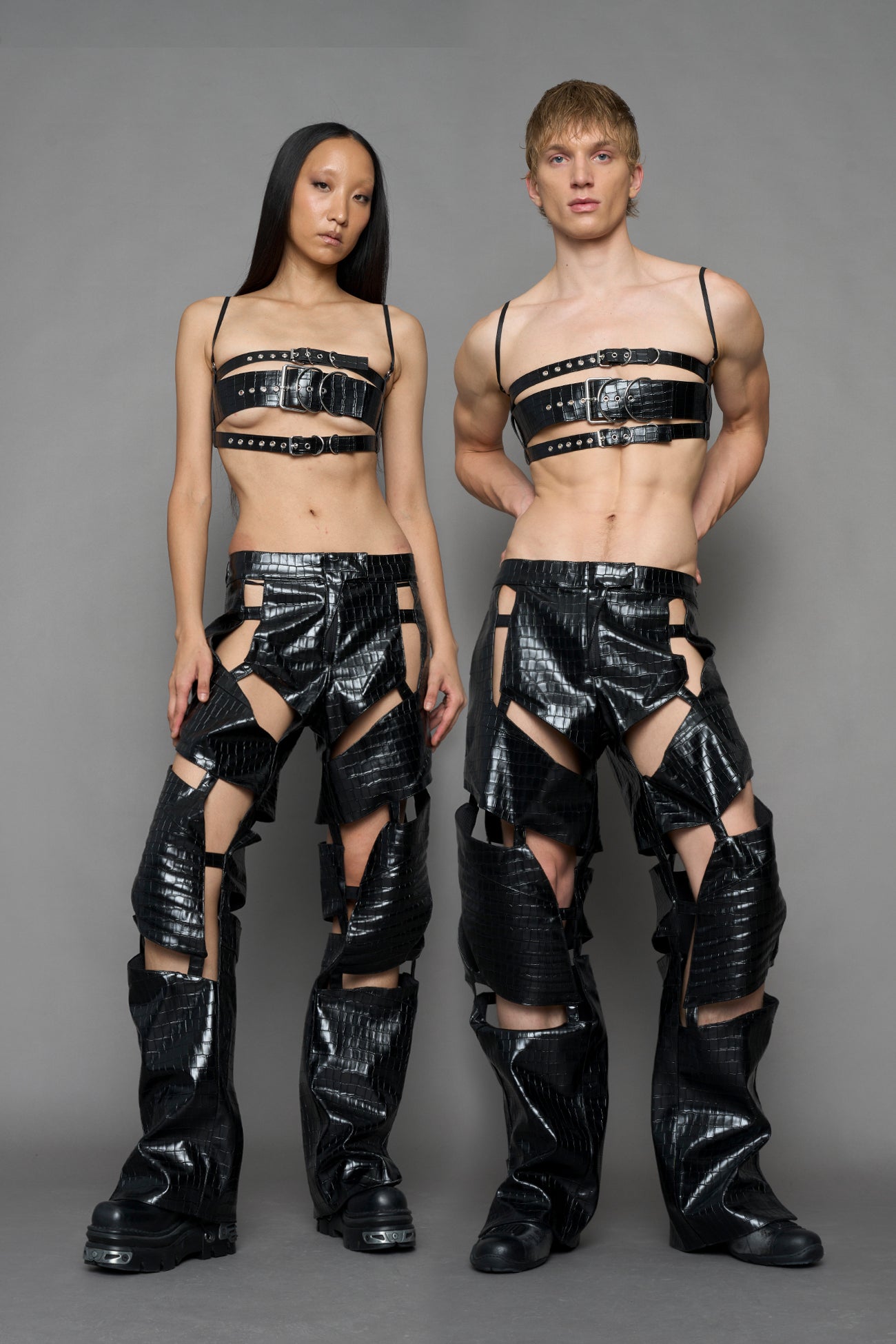 two models wearing black croc vegan leather pants with cut out details