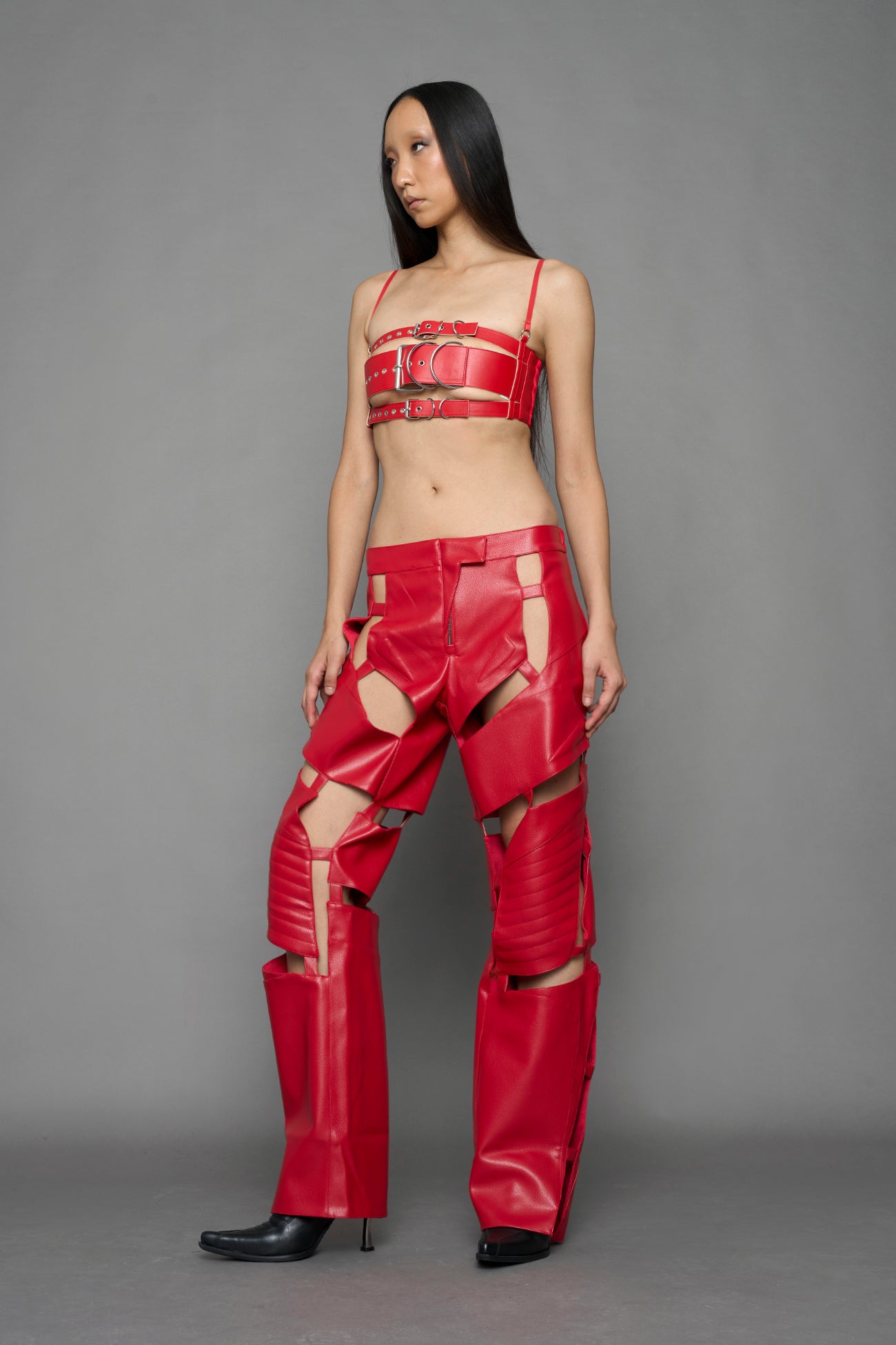 model wearing red vegan leather pants with cut outs