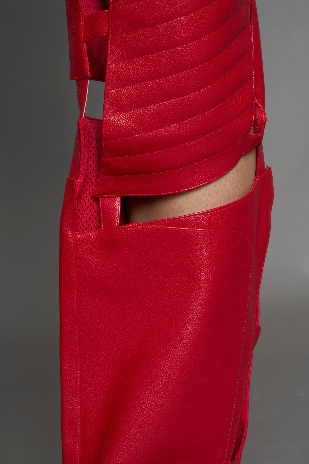 model wearing red vegan leather pants with cut outs