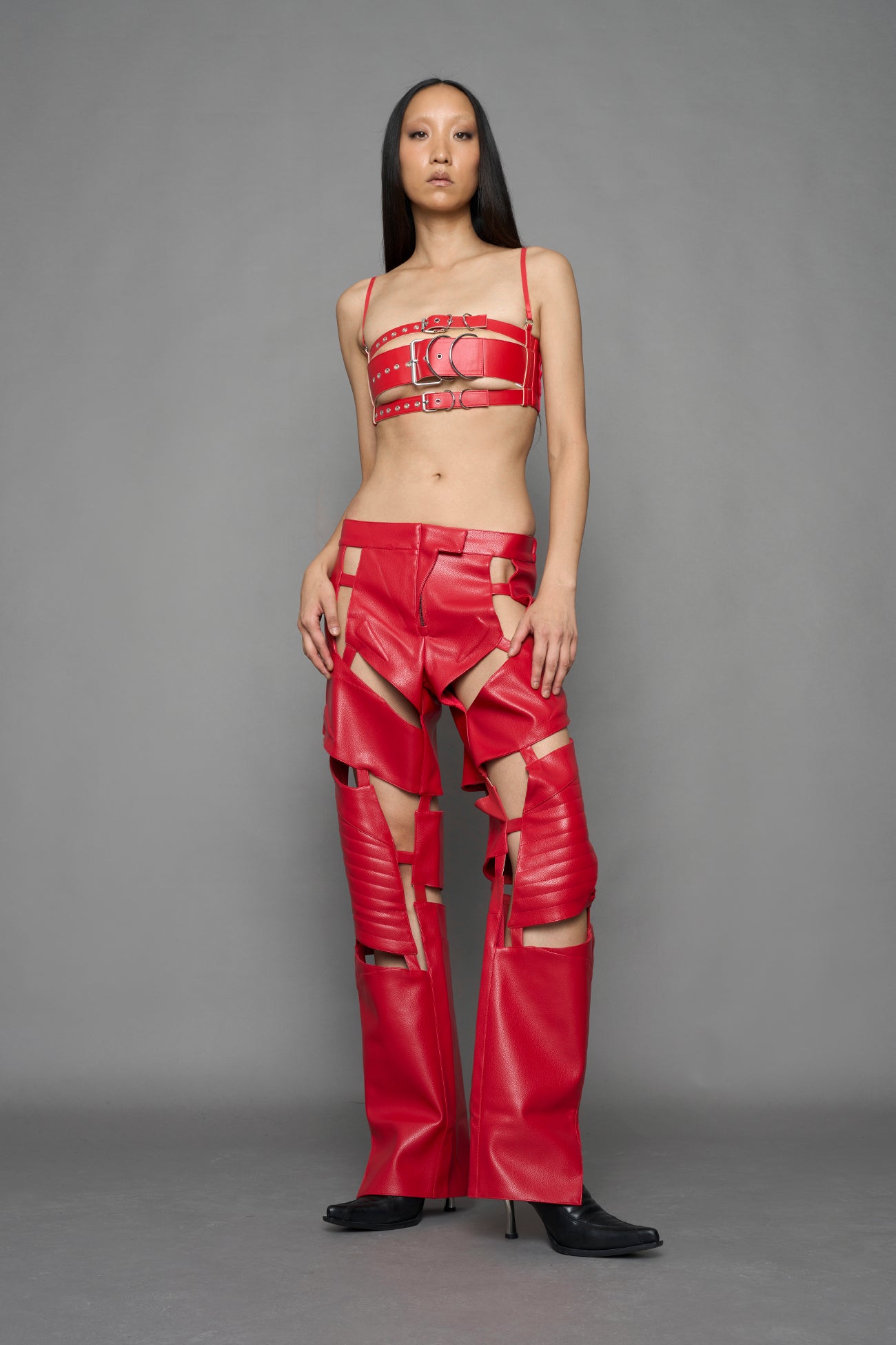 model wearing red vegan leather pants with cut outs