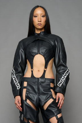 A model wearing a black faux-leather futuristic bodysuit with a high collar