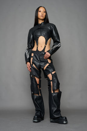 A model wearing a black faux-leather jacket with logo on the arm
