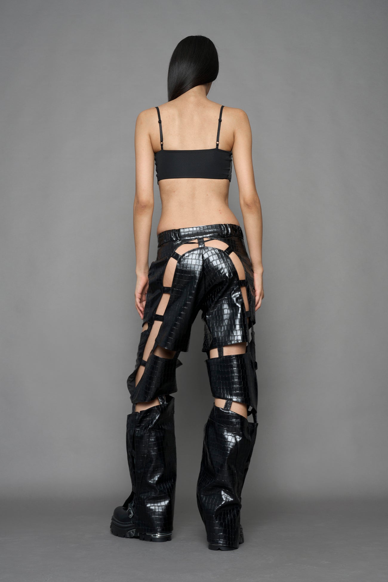 model wearing black croc vegan leather pants with cut out details