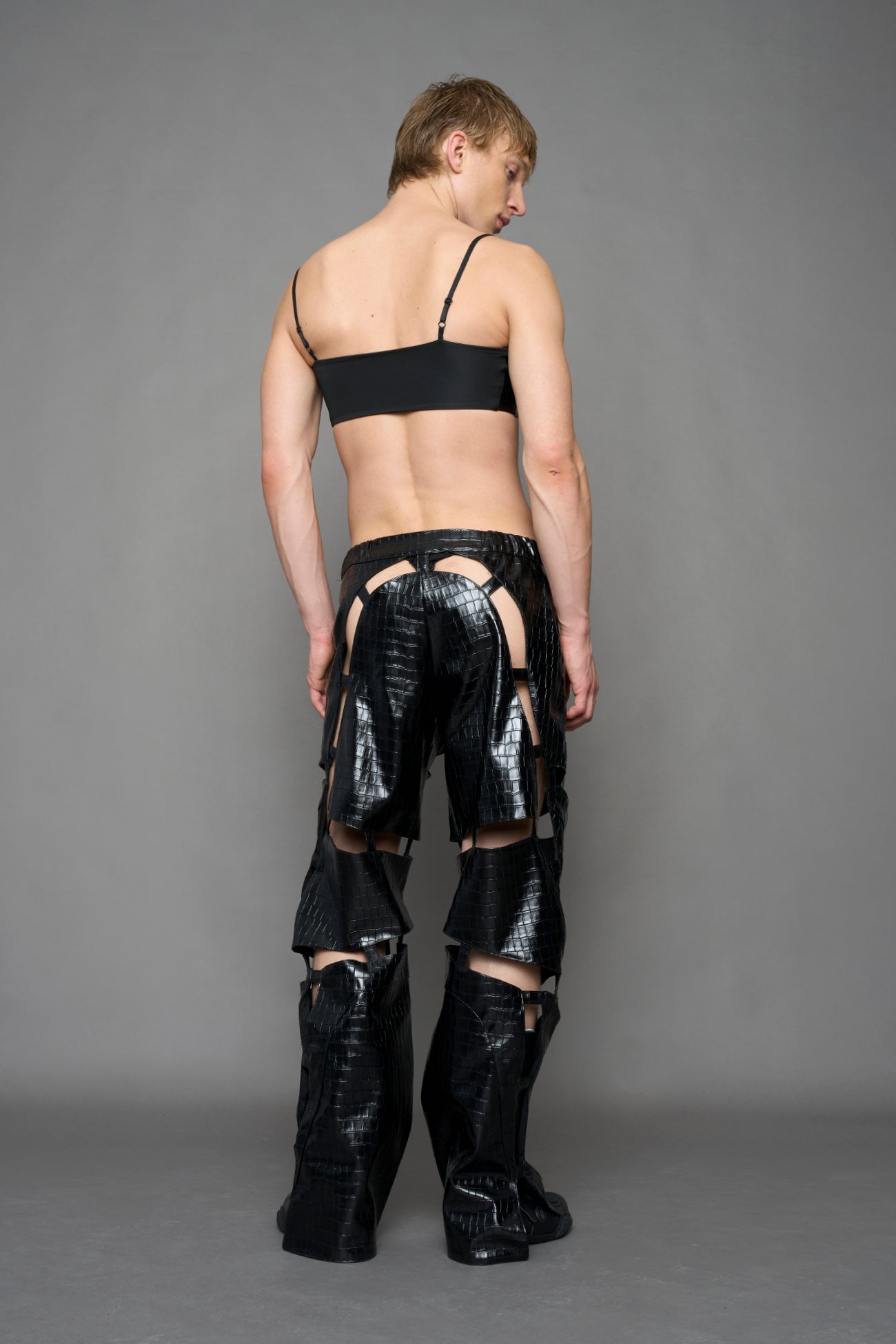 model wearing black vegan leather croc inspired belt top with buckle details