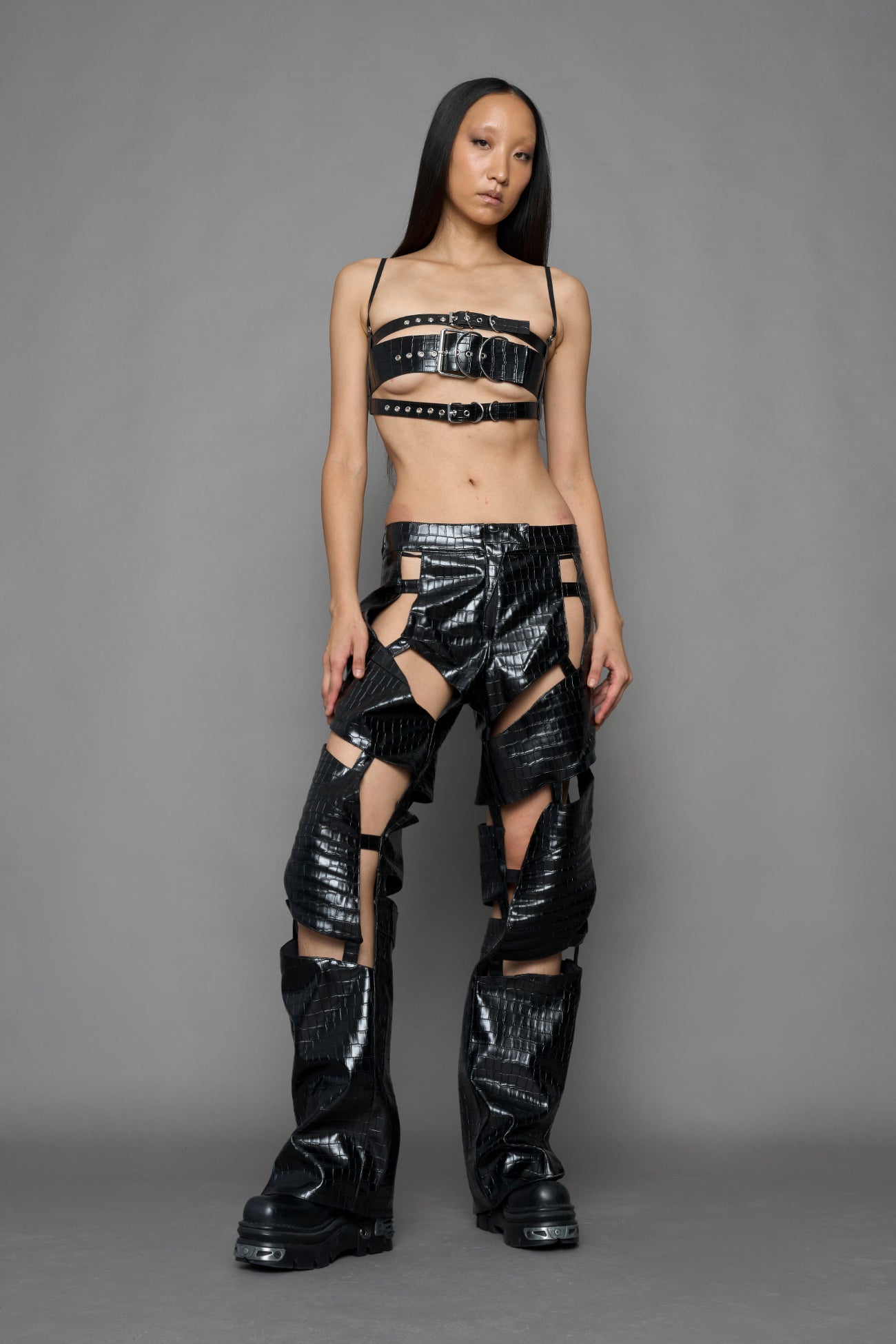 model wearing black croc vegan leather pants with cut out details