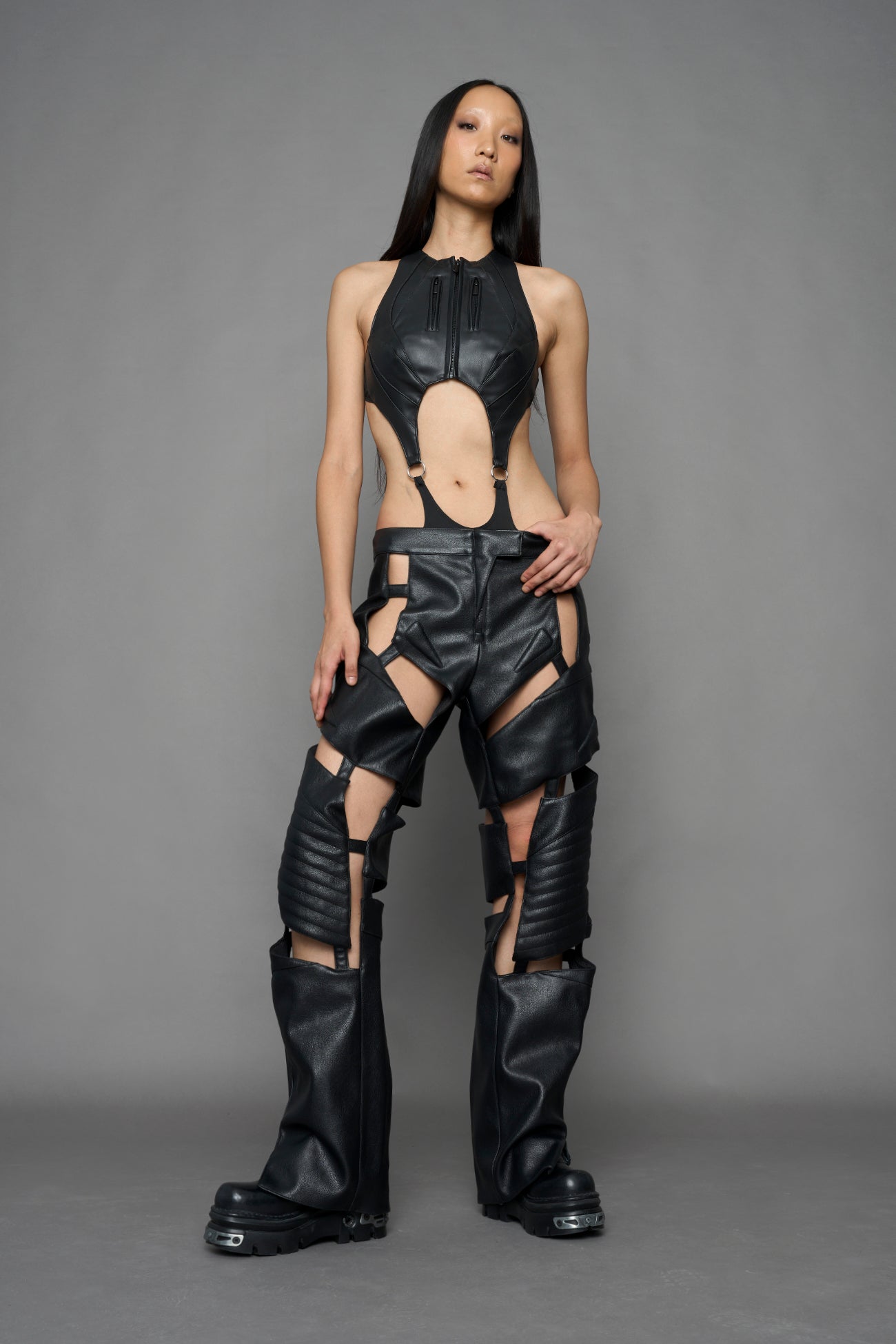 model wearing black vegan leather pants with cu outs