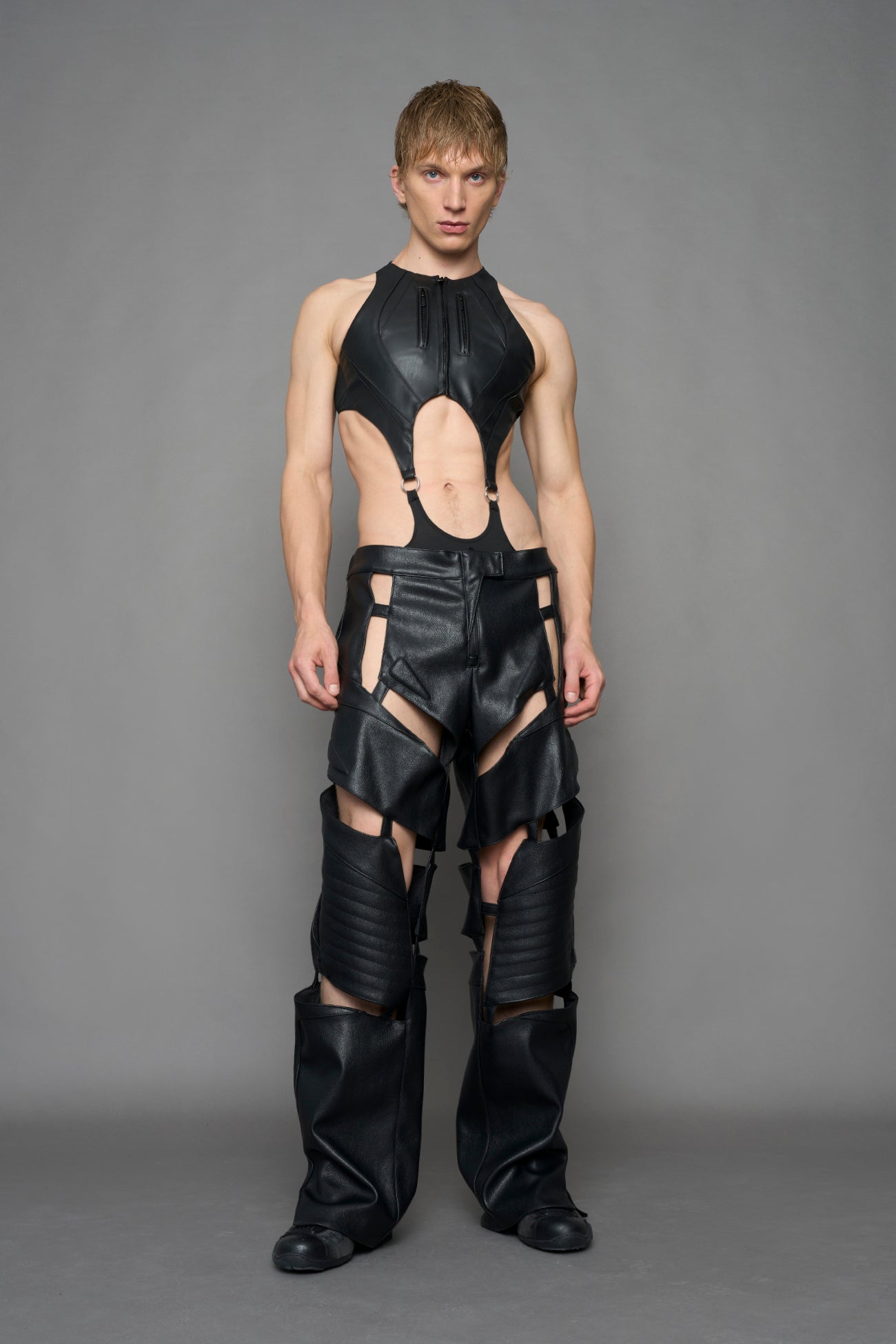 model wearing black vegan leather pants with cu outs