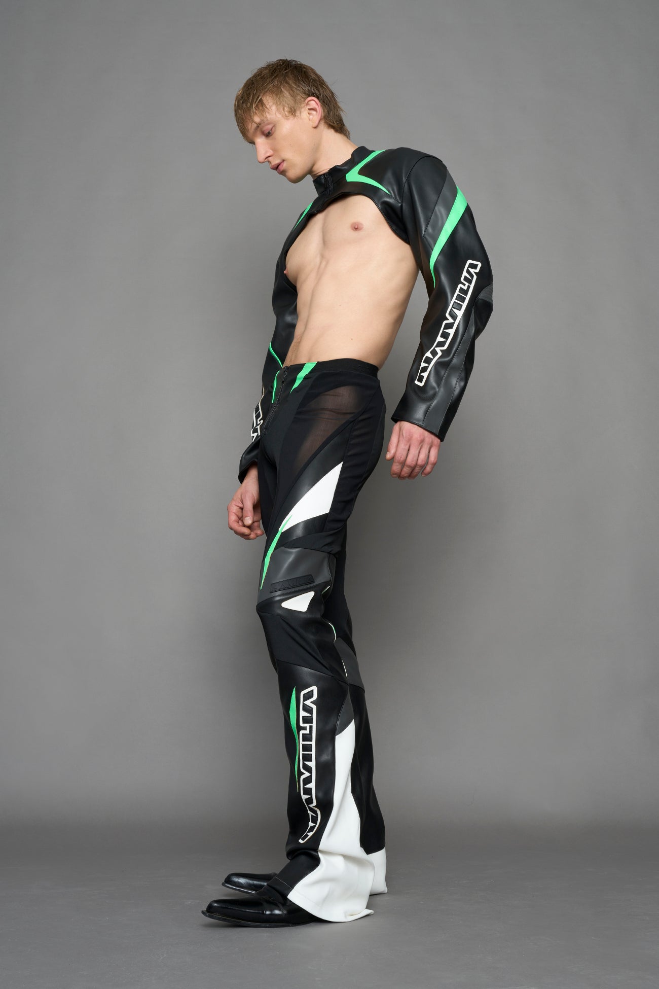 model wearing black white green moto inspired mesh pants with logo on the leg