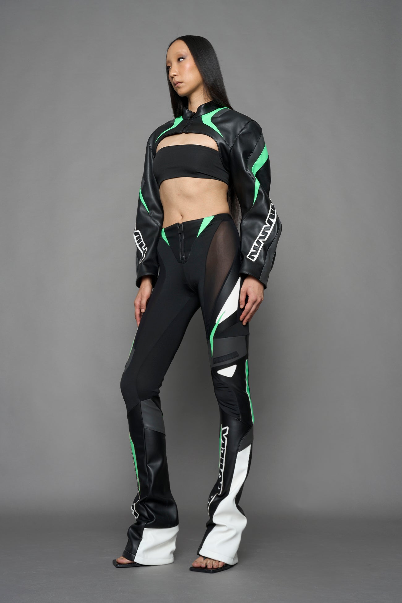 model wearing black white and green cropped jacket with logo on the arm