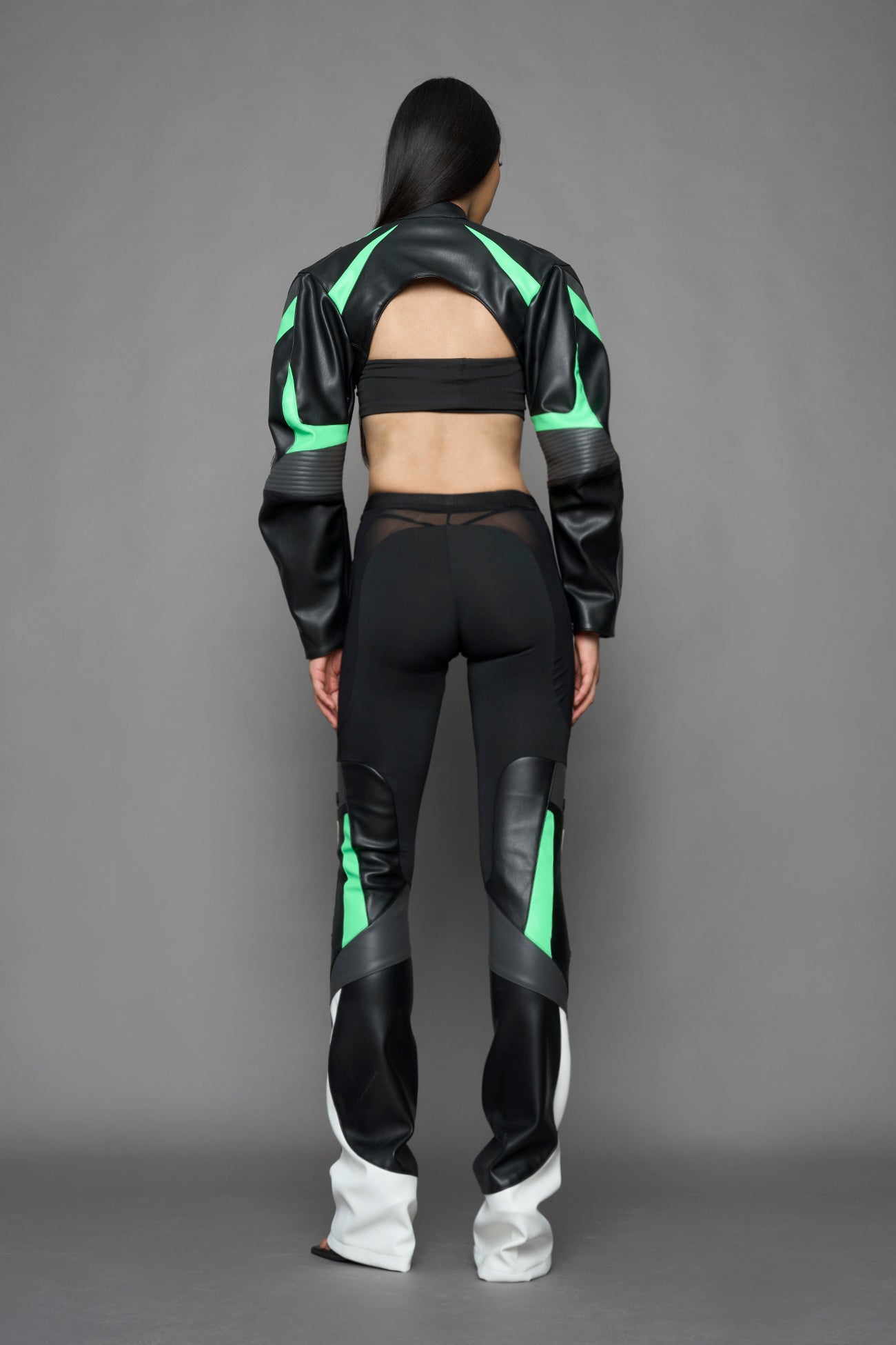 model wearing black white and green cropped jacket with logo on the arm