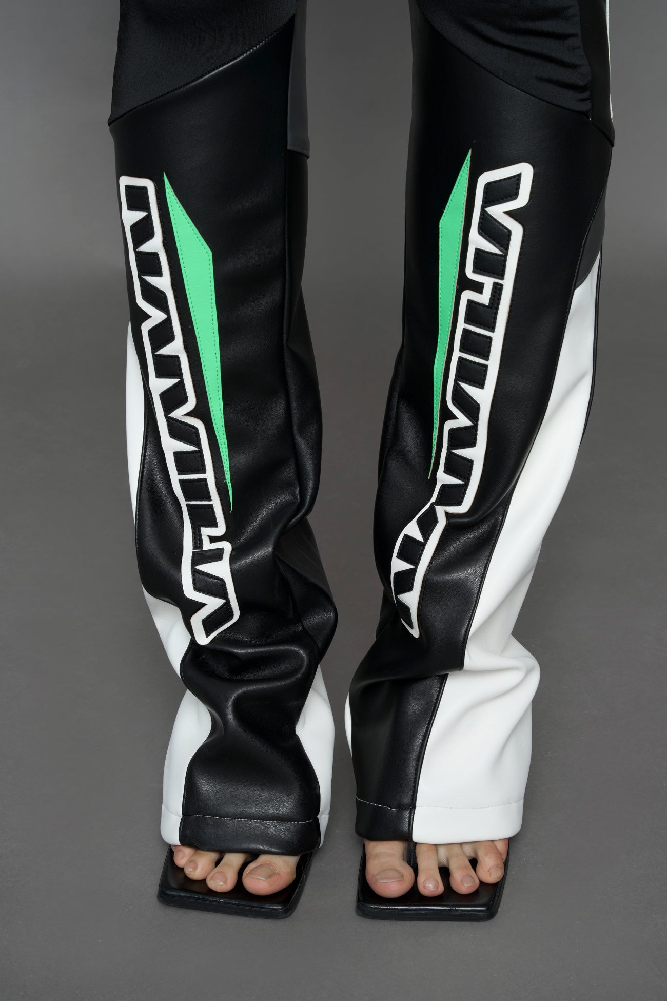 model wearing black white green moto inspired mesh pants with logo on the leg