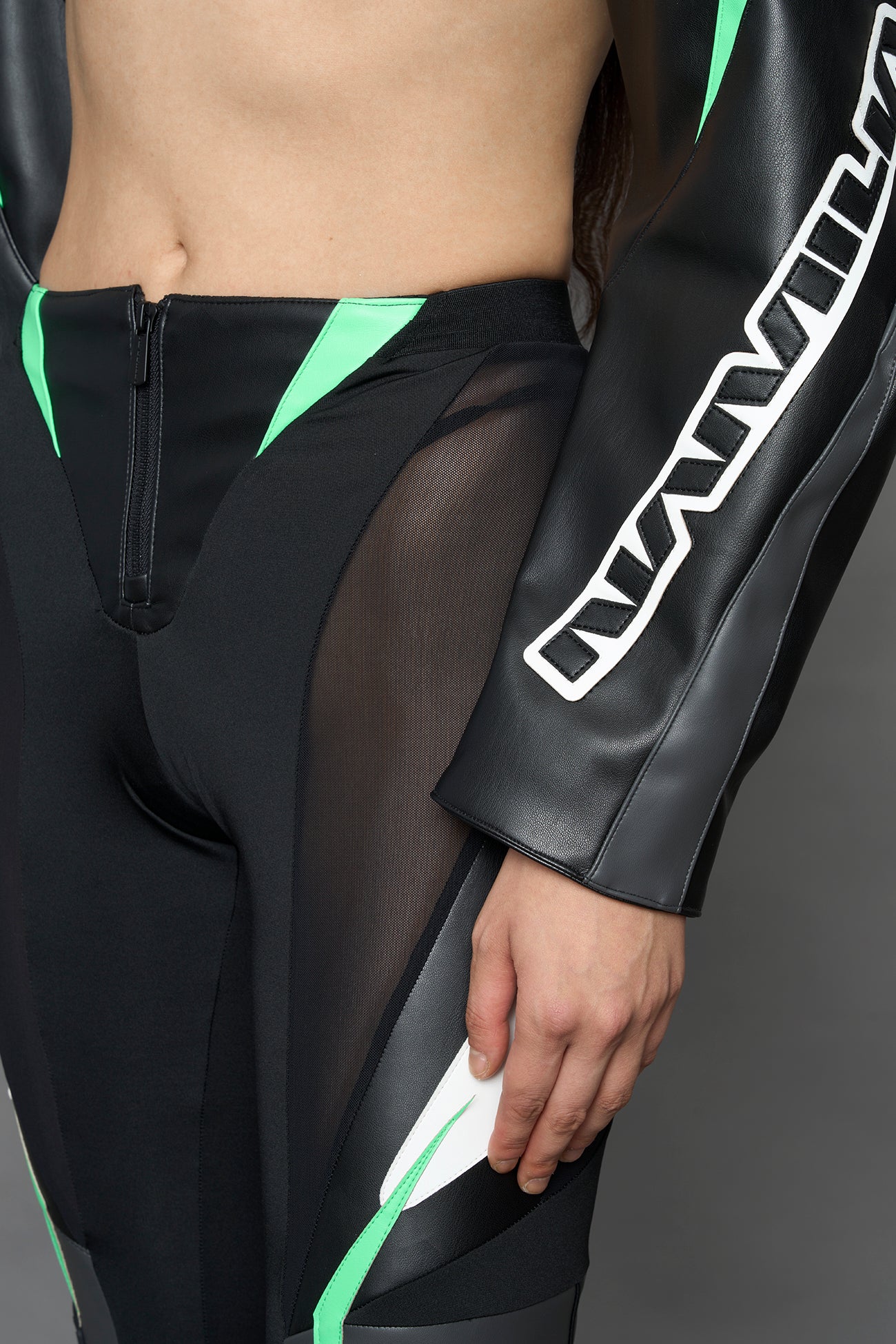 two models wearing black white green moto inspired mesh pants with logo on the leg