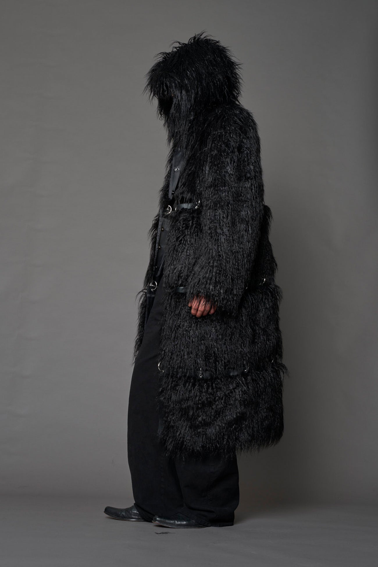 model wearing black faux fur coat with silver metal rings