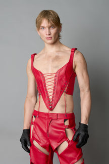 Model wearing red vegan leather XTC Corset by Namilia featuring extreme plunging neckline, front lace-up closure, and sculpted fit