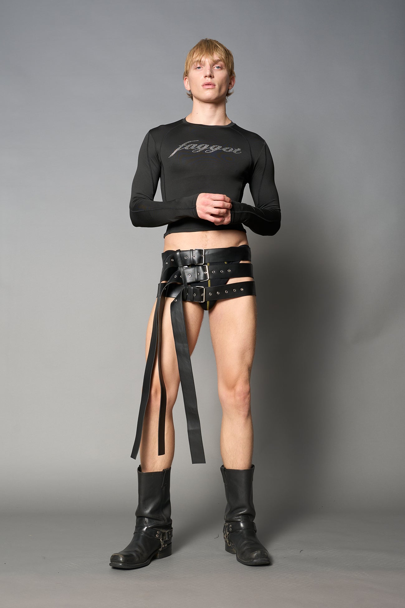 Black vegan leather belt skirt with multiple oversized grommet belts and long straps – edgy Y2K-inspired mini skirt for statement streetwear or club looks.

