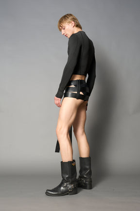 Black vegan leather belt skirt with multiple oversized grommet belts and long straps – edgy Y2K-inspired mini skirt for statement streetwear or club looks.

