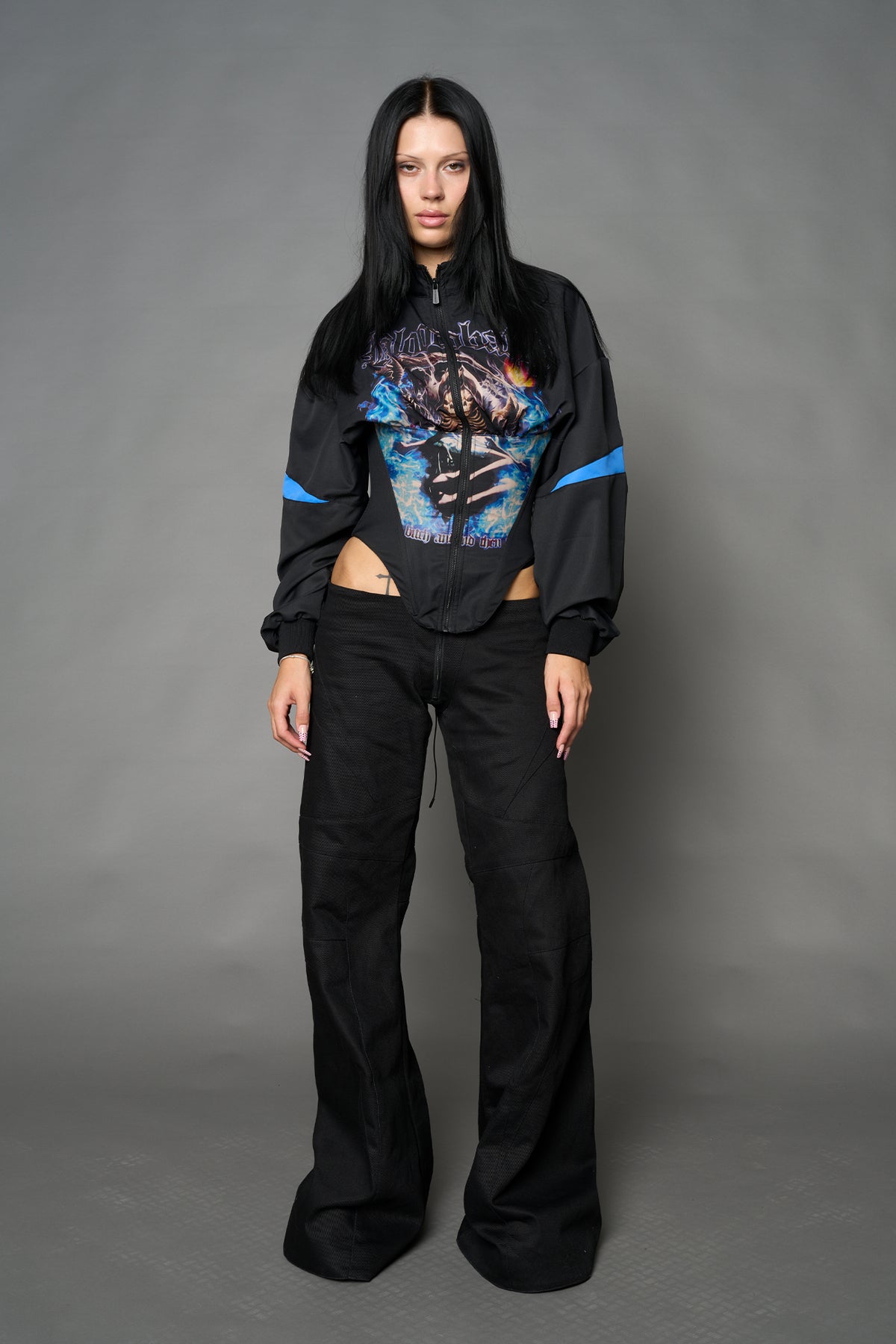 Black Namilia cropped tracksuit jacket with sleeve stripes, gothic graphic print, and lace-up corset back