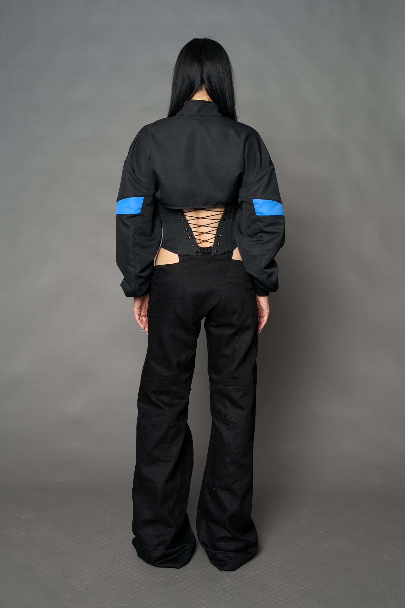 Black Namilia cropped tracksuit jacket with sleeve stripes, gothic graphic print, and lace-up corset back