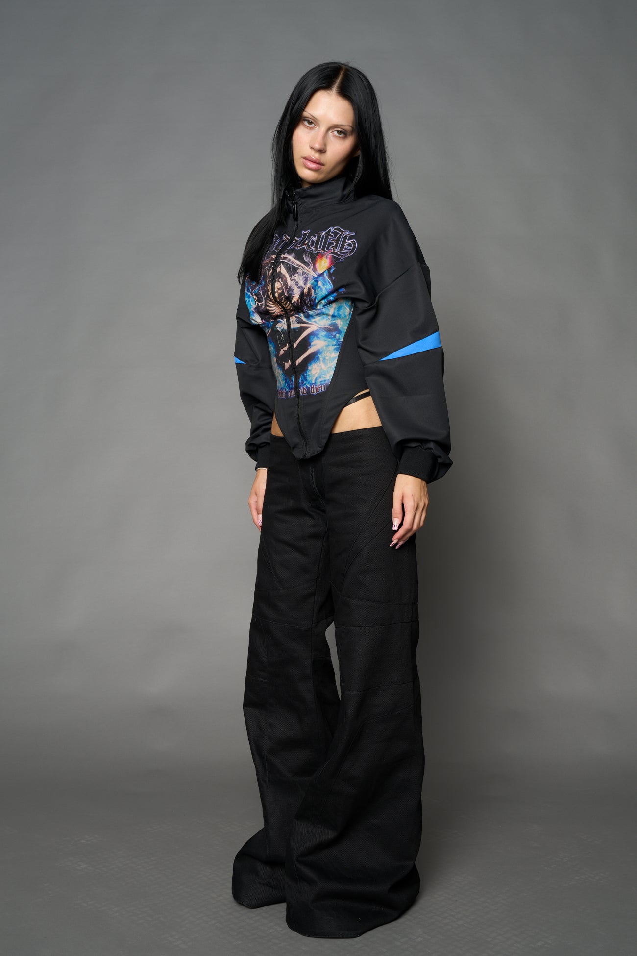 Black Namilia cropped tracksuit jacket with sleeve stripes, gothic graphic print, and lace-up corset back