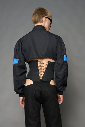 Black Namilia cropped tracksuit jacket with sleeve stripes, gothic graphic print, and lace-up corset back