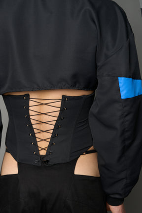 Black Namilia cropped tracksuit jacket with sleeve stripes, gothic graphic print, and lace-up corset back