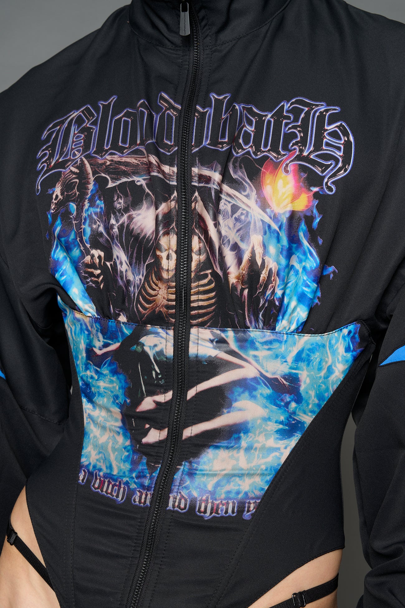 Black Namilia cropped tracksuit jacket with sleeve stripes, gothic graphic print, and lace-up corset back