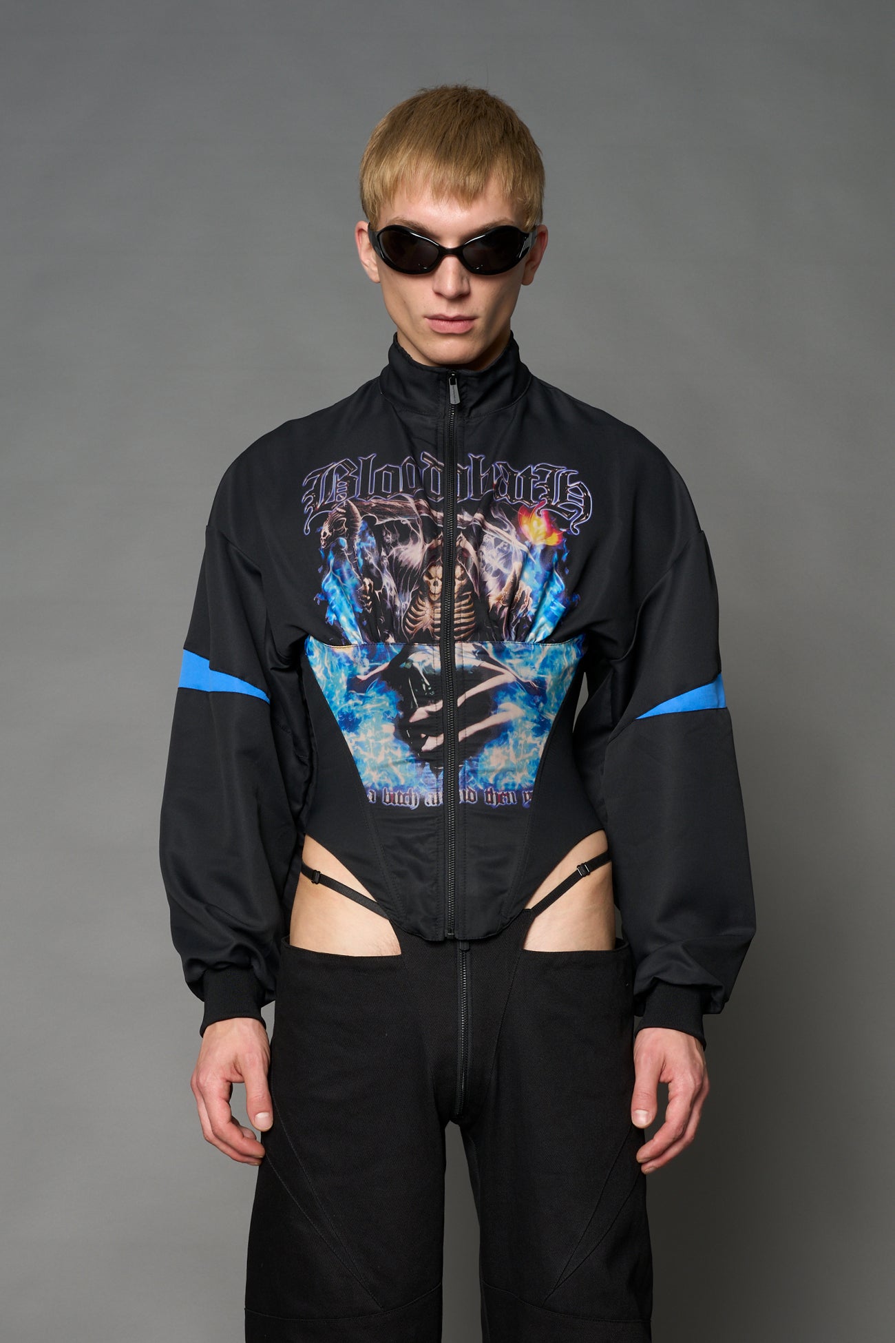 Black Namilia cropped tracksuit jacket with sleeve stripes, gothic graphic print, and lace-up corset back