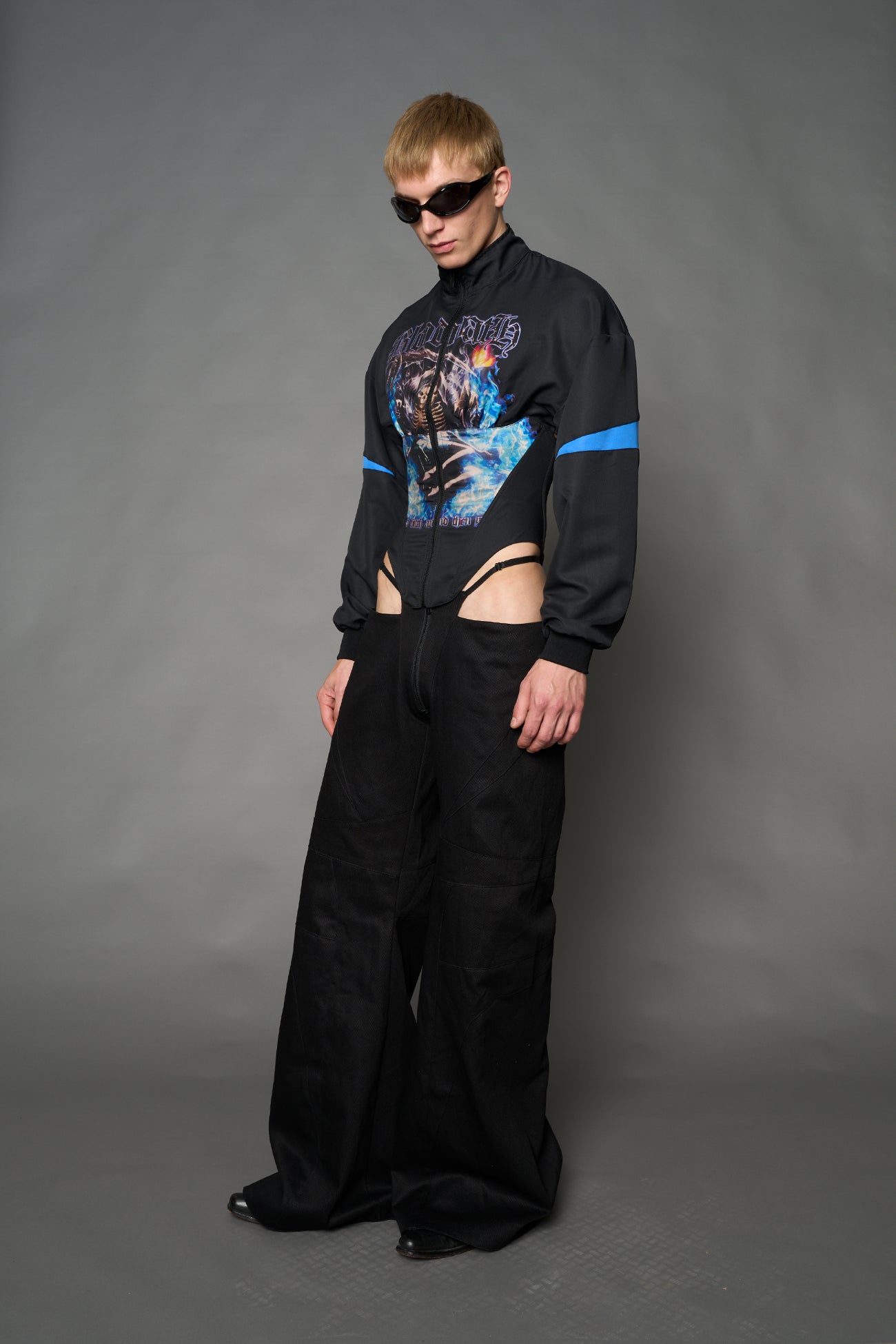 Black Namilia cropped tracksuit jacket with sleeve stripes, gothic graphic print, and lace-up corset back
