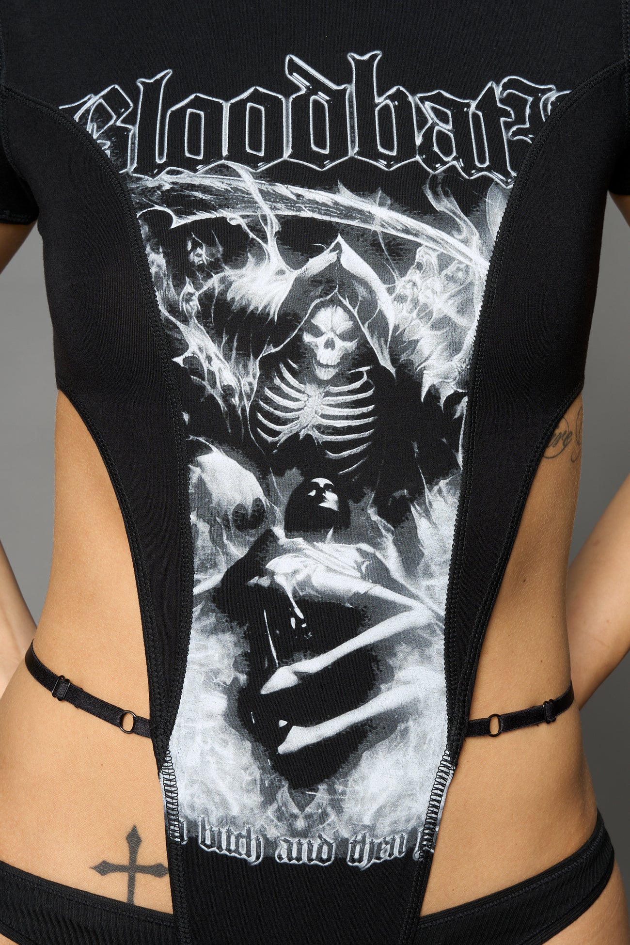 Black Namilia Bloodbath bodysuit with gothic skeleton graphic, cut-out sides, high-cut leg and strap details