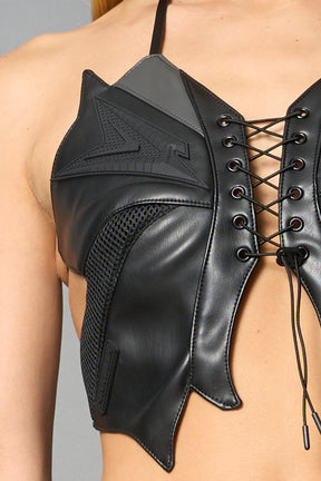 model wears black vegan leather butterfly crop top with lace-up front, halter straps, and mesh accents – edgy Y2K-inspired statement piece for festivals or streetwear.