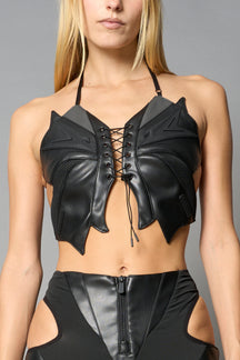 black vegan leather butterfly crop top with lace-up front, halter straps, and mesh accents – edgy Y2K-inspired statement piece for festivals or streetwear.
