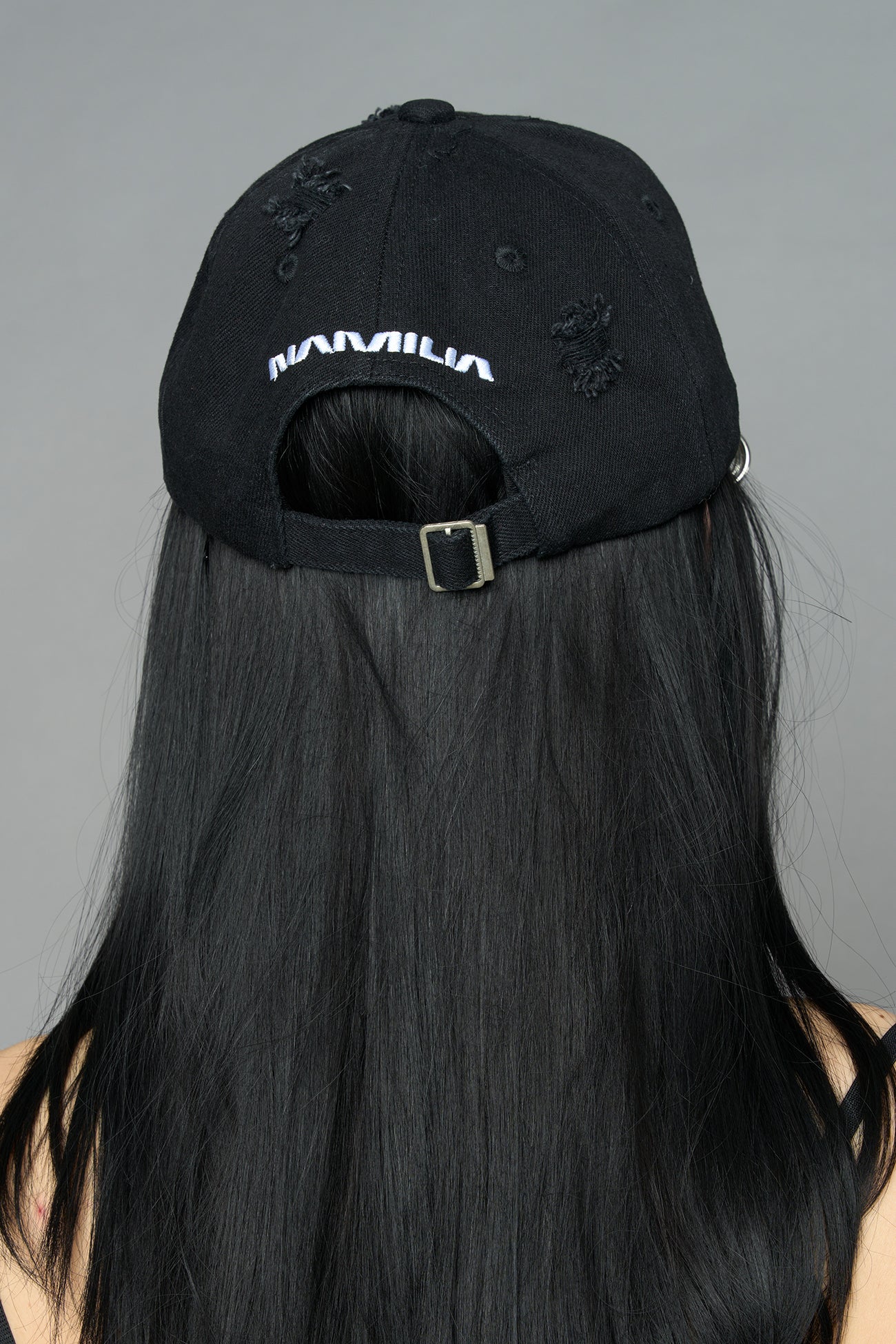 model wearing black red slogan embroidered rtrucker cap with silver ring details