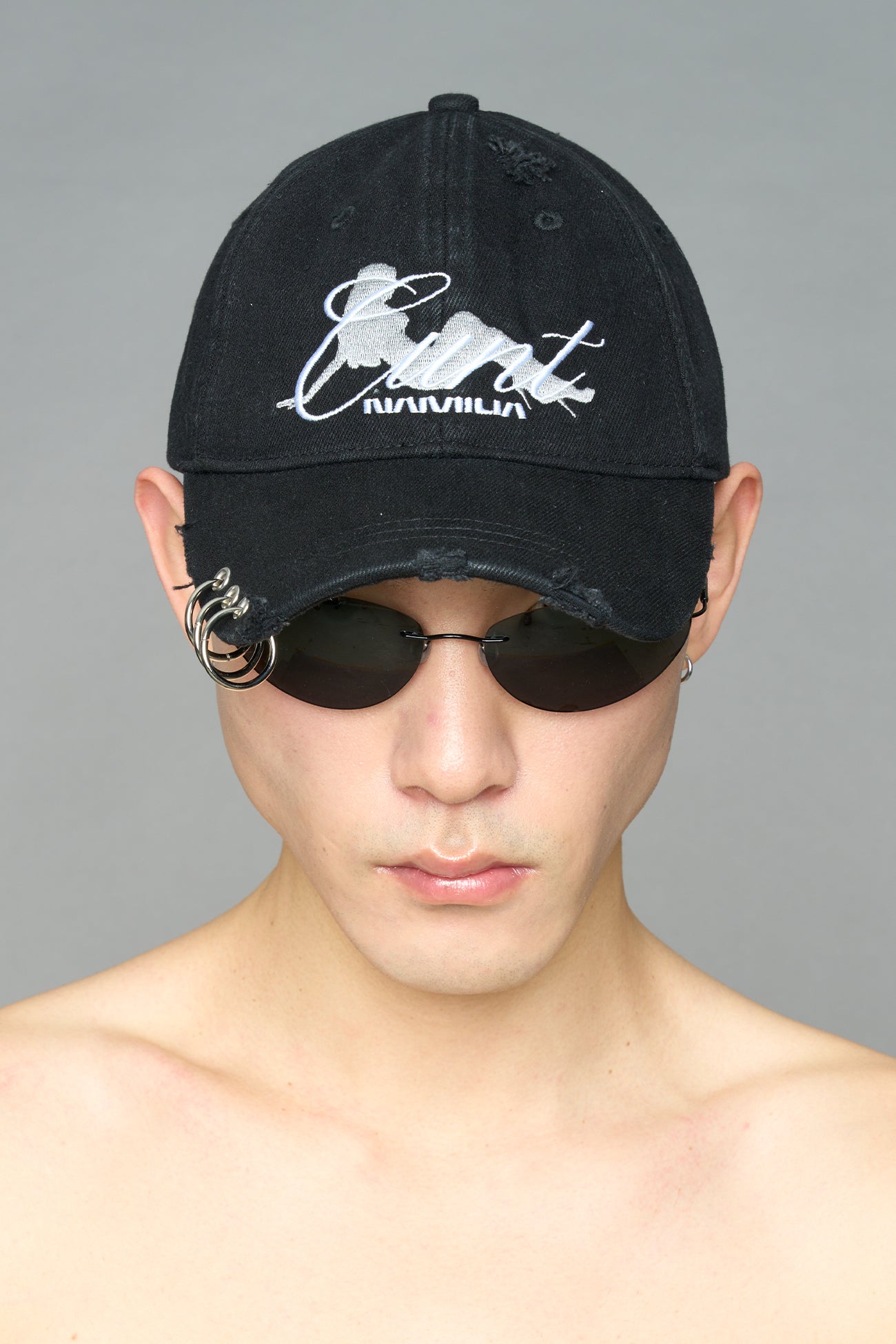 model wearing black grey slogan embroidered rtrucker cap with silver ring details