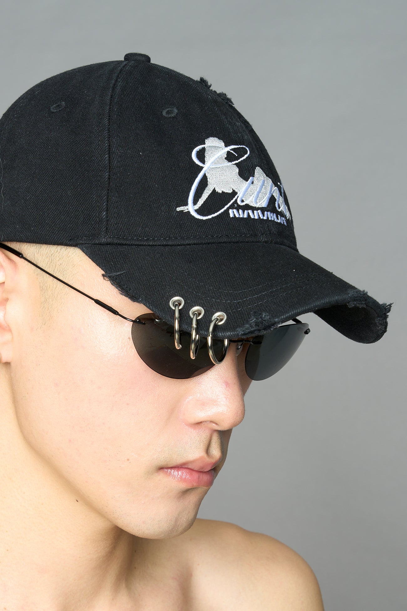model wearing black red slogan embroidered rtrucker cap with silver ring details