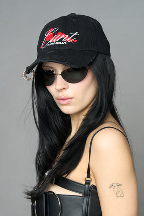 model wearing black red slogan embroidered rtrucker cap with silver ring details