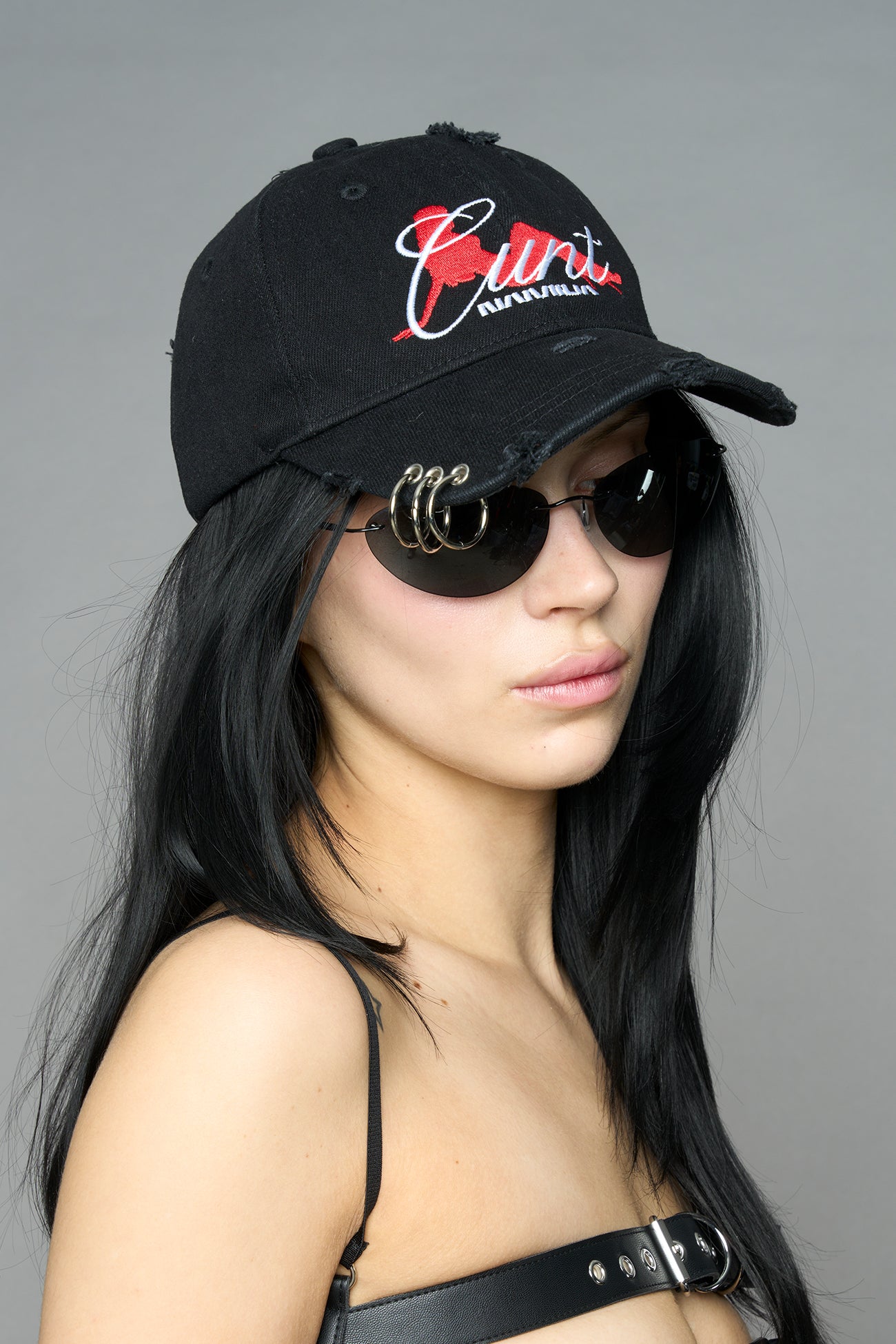 model wearing black red slogan embroidered rtrucker cap with silver ring details
